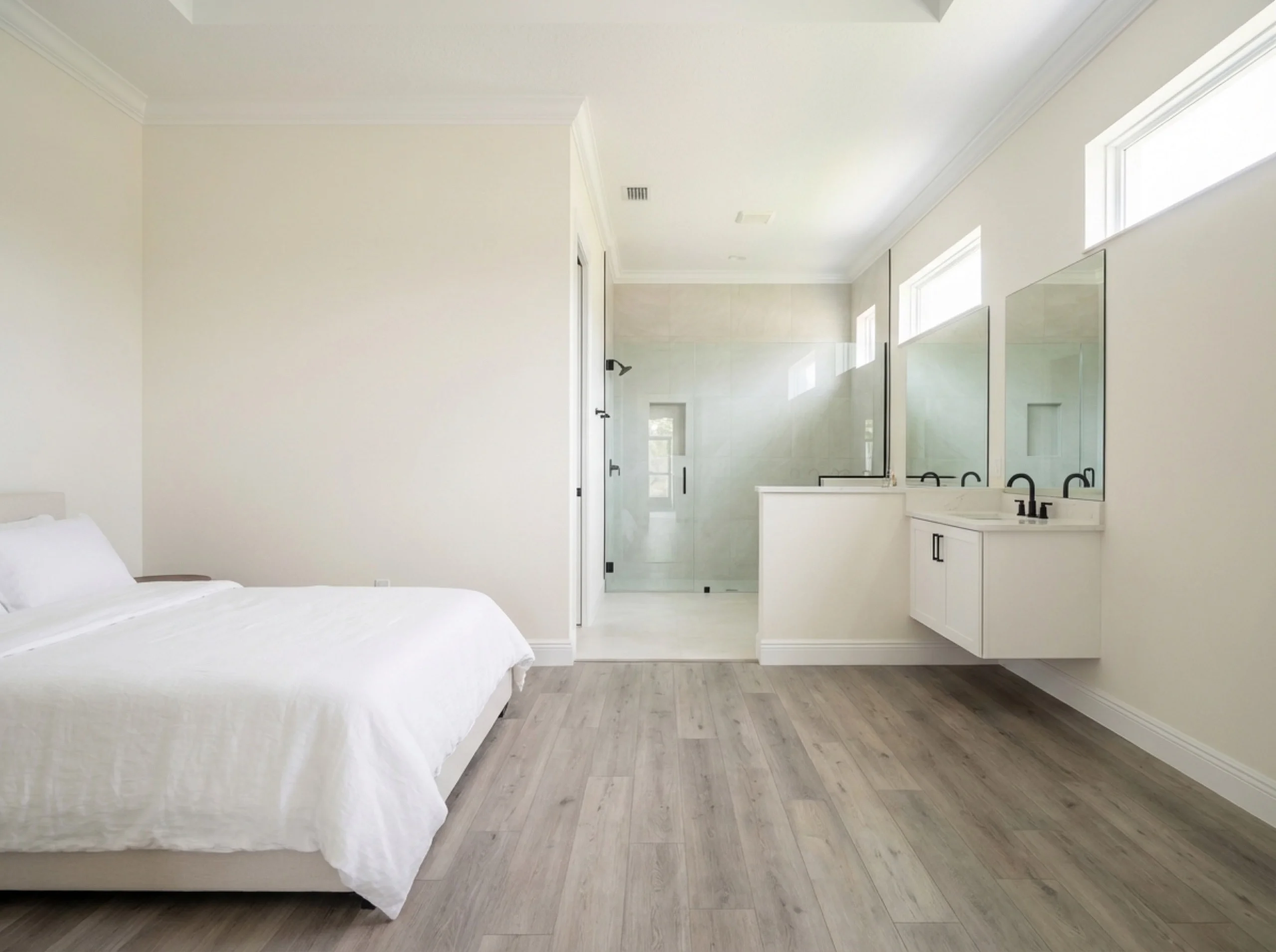 Spa-style Nokomis bathroom edge with gray-washed LVP continuing from an adjacent bedroom