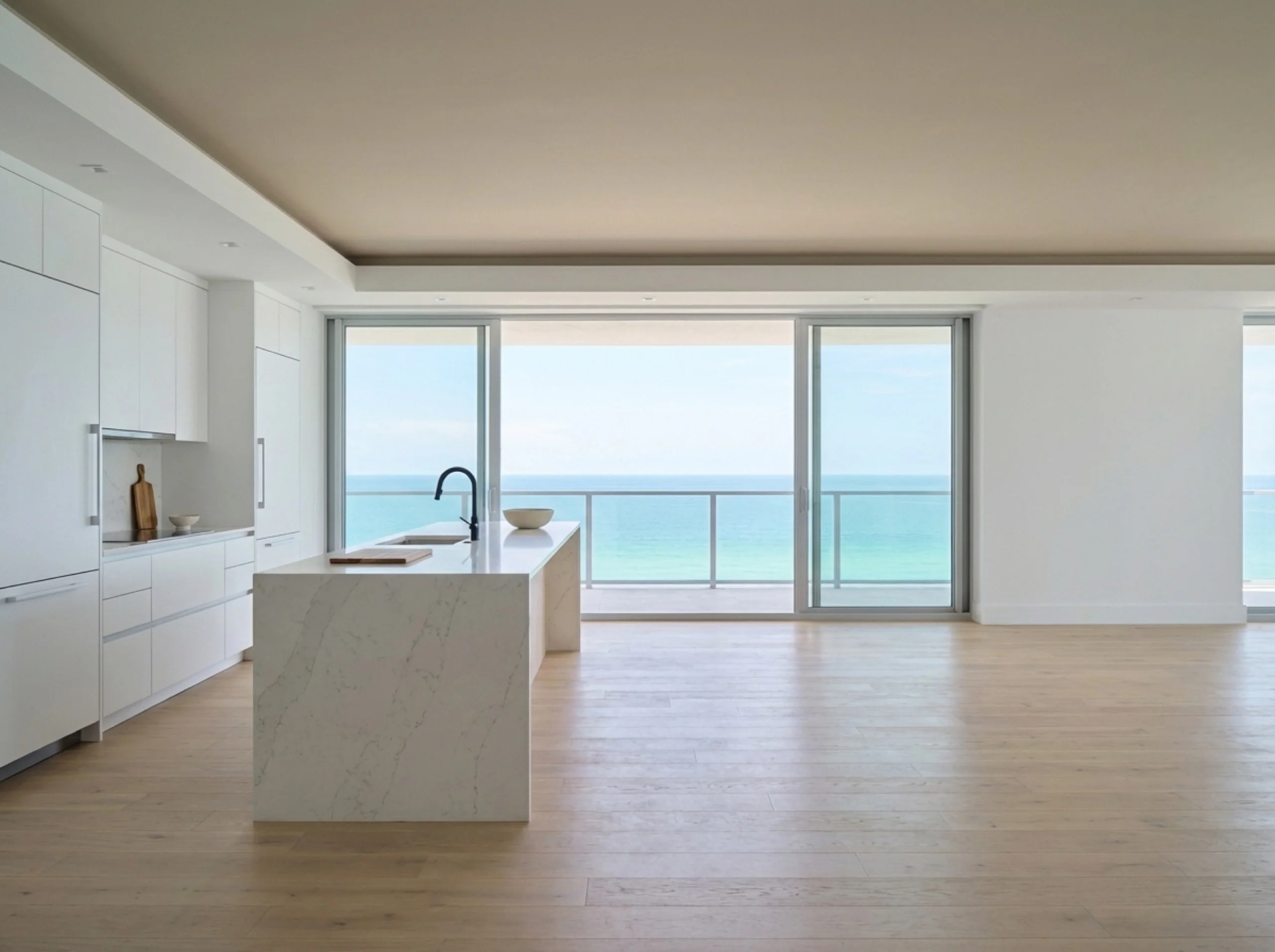 Longboat Key kitchen with a quartz waterfall island and oak flooring handing off to balcony sliders over water
