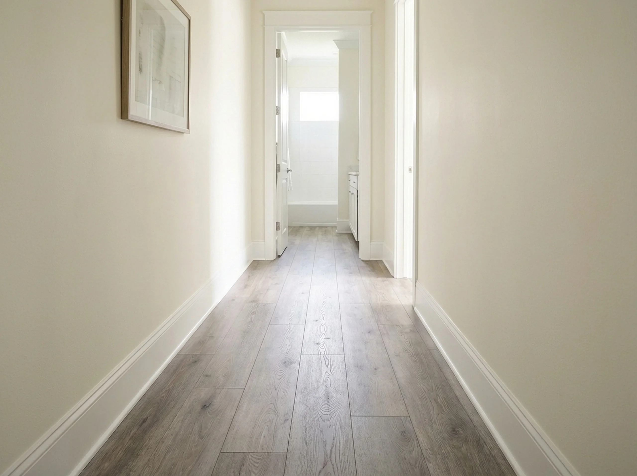 Luxury vinyl plank hallway leading into a bathroom doorway
