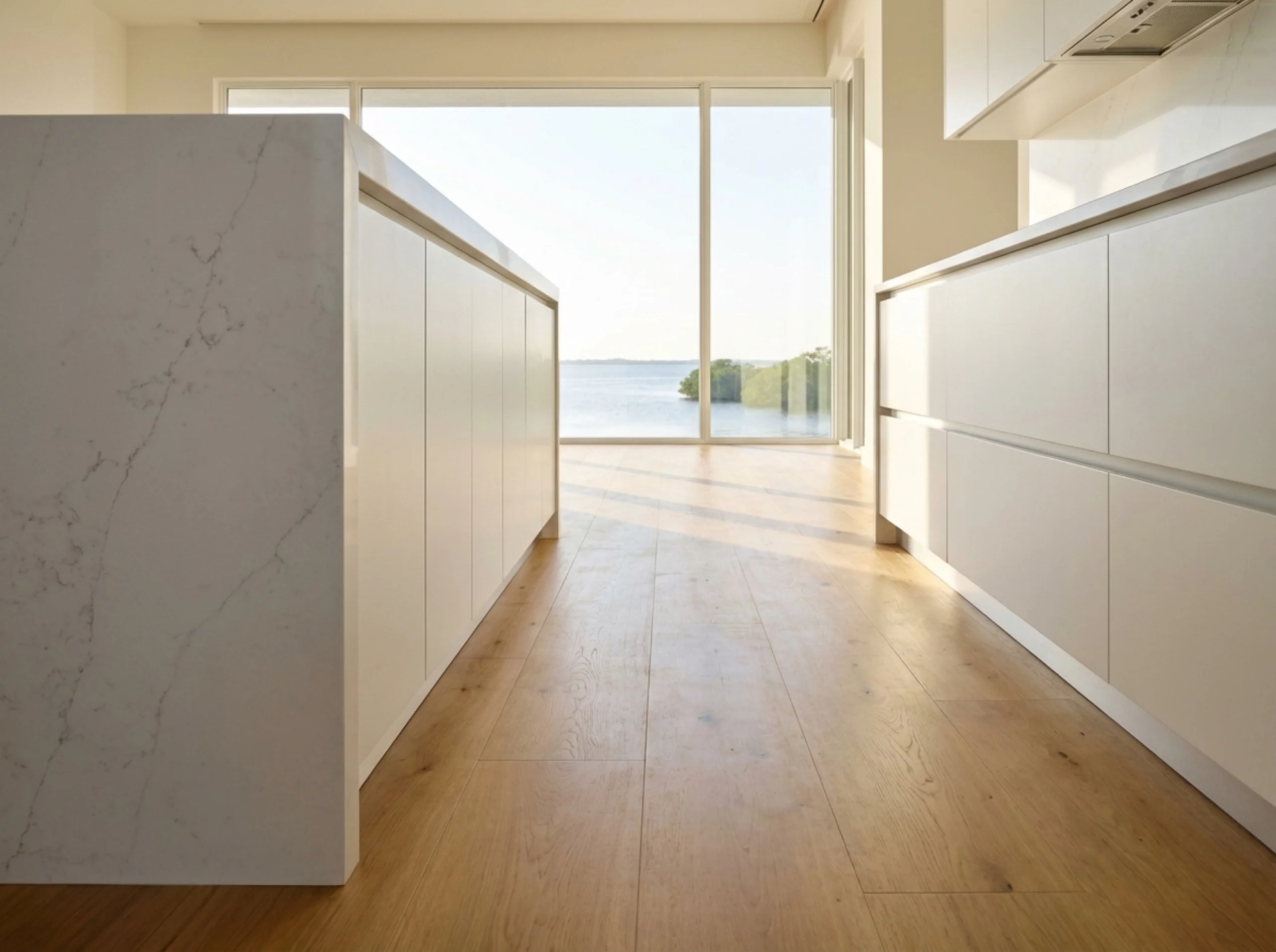 Osprey kitchen island edge with plank flooring running under the cabinet toe-kick
