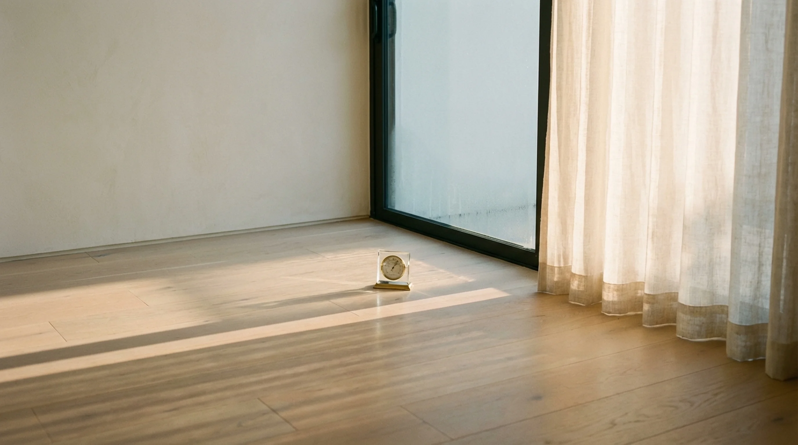 Brass hygrometer on a white oak floor near a sliding glass door in a coastal Florida home